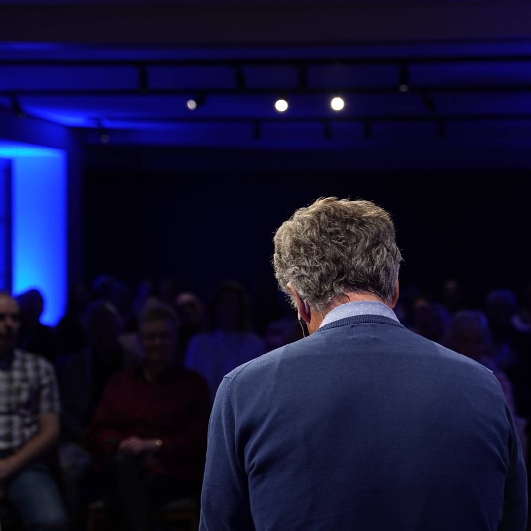 Nick Wilder, von hinten bei seiner Lesung spricht, Publikum im Hintergrund.